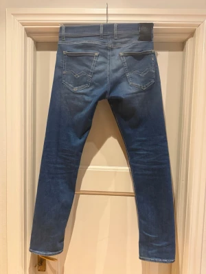 Blå Replay jeans med raka ben - Snygga blå jeans från Replay med klassisk femficksdesign och raka ben. Jeansen har diskreta slitningar framtill och tydliga sömmar på bakfickorna. Perfekta för en avslappnad och trendig look.