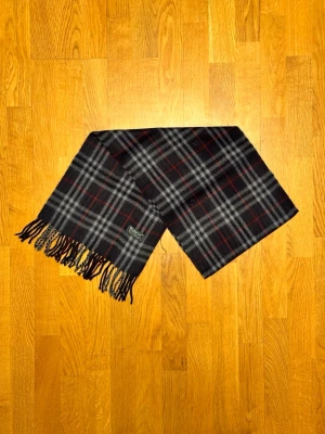 Mörkblå Burberry halsduk - Säljer är mörkblå halsduk från Burberry. Halsduken är i gott skick och är gjord i 100% lamull. Var inte rädd för några frågor. Pris diskuteras inte!