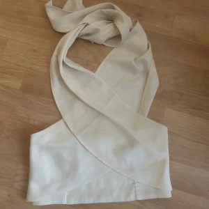  omlott topp med knytband - Säljer en beige omlott topp med långa knytband som kan stylas hur man vill. Super snygg! Helt oanvänd prislapp sitter kvar.🤗 Kan även passa bra till halloween som tillexempel mumie eller cleopatra😁