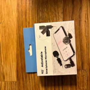 90° Adjustable Smartphone Microphone - Praktisk 90° justerbar mikrofon för smartphone. Perfekt för inspelning och samtal, enkel att ansluta via 3,5 mm kontakt. Levereras i originalförpackning, ser oanvänd ut och passar de flesta mobiler. Inga synliga defekter eller slitage.
