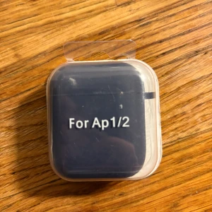 AirPods 1/2 Silikonskal - Skyddande silikonskal för AirPods generation 1 och 2. Ny i förpackning, svart färg. Perfekt för att skydda ditt AirPods-fodral mot repor och stötar. Passar både AirPods 1 och AirPods 2. 