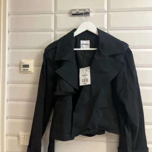 Svart jacka från Bershka - Snygg svart jacka från Bershka med en stilren design. Jackan har en klassisk krage och långa ärmar, perfekt för en trendig look. Passar bra till både vardag och speciella tillfällen. Aldrig använd eller testad. Köpt från Bershka. Säljer för 225 kronor 