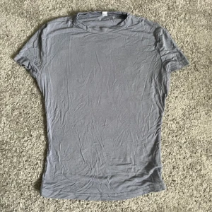 Grå-blå basic t-shirt i bomull - Enkel grå-blå t-shirt med rund hals och korta ärmar. T-shirten har en clean och stilren look, perfekt att matcha med jeans eller shorts. Tillverkad i mjuk bomull för en skön känsla hela dagen. Stretching material!