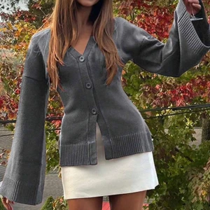 Grå kofta med vida ärmar - Säljer en grå kofta med v-ringning och stora knappar framtill. Koftan har extra vida, långa ärmar och breda ribbade muddar vid ärmslut och nederkant. Perfekt för lager-på-lager och chill höststil. Från SHEIN, aldrig använd, originalpris 279kr