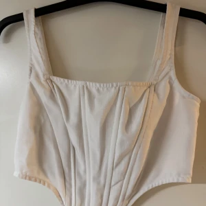 Vit korsett-topp med dragkedja - Säljer en vit korsett-topp med breda axelband