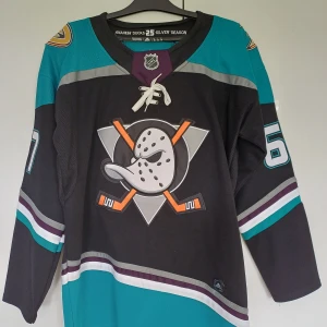 Anaheim Ducks NHL Hockeytröja. - Säljer en Anaheim Ducks Hockeytröja i Jättefint skick med trycket Rakell nummer 67. Det enda är att det är en liten smuts fläck men försvinner säkert med en tvätt se bild 4 och en söm har gått upp se bild 5. Storlek: M     skicka iväg ett meddelande om du undrar något. :) 