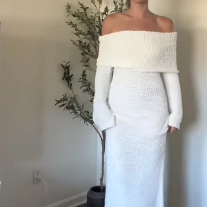 Vit offshoulder långklänning - Supersnygg vit långklänning med offshoulder och långa ärmar. I helt nytt skick, aldrig använd med prislapp på. Säljer pga av att den är för stor på mig. Original pris 800kr