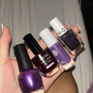 Fyra nagellack i lila och vinrött - Säljer fyra snygga nagellack i olika nyanser: glittrigt lila från W7, mörkt vinrött från Nocibé, pastellila från Yves Rocher och mörklila glitter från Sephora. Perfekta för att skapa unika nagellooks. Alla flaskor har klassisk form och svarta eller vita korkar.