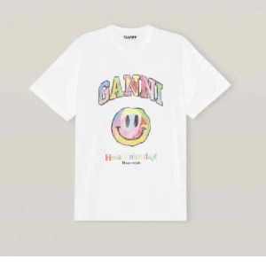 Vit Ganni t-shirt med smileytryck - Vit t-shirt från Ganni med färgglatt tryck framtill. Overzised passform och rund halsringning. Perfekt för dig som gillar lekfulla och unika prints💗