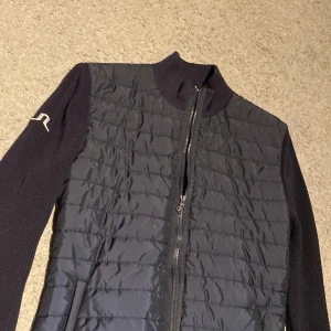 Svart quiltad jacka från J.Lindeberg - Säljer en cardigan från J. Lindeberg med märke på ena armen. Storlek S-XS Skriv vid frågor