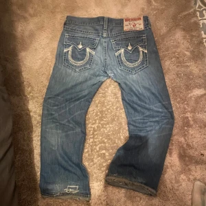 Perfekta baggy true religion jeans  - Riktigt snygga baggy true religion jeans med en skön fade. lagningar på vissa ställen och ett litet hål på baksidan 