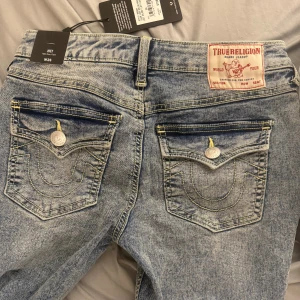 True Religion Joey Flare Jeans ljusblå - Säljer ett par True Religion Joey jeans i ljusblå tvätt med flare-ben och snygga bakfickor. Helt oanvända, köpta i usa när jag var där i somras för ca 1600kr, skriv vid frågor/ pris går att diskutera vid snabb affär