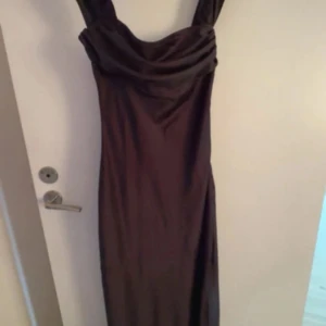 Svart lång satinklänning med offshoulder - denna köptes till balen förra året men blev tyvärr inte till användning.  Ljuset på bilden gör att den ser lite brun ut men den är svart.
