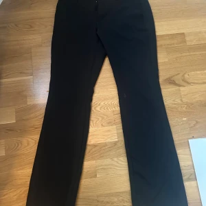 Svarta kostymbyxor från Bik Bok - Snygga svarta kostymbyxor från Bik Bok i klassisk bootcute. Byxorna har en stilren design med normal passform och är tillverkade i ett mjukt tyg som ger en dressad look. Perfekta att matcha med en skjorta eller stickad tröja.