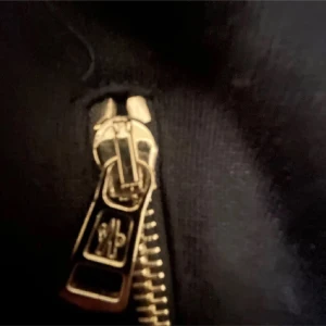 Svart/mörklblå zip hoodie från Moncler - Svart hoodie från Moncler med dragkedja framtill och två sidofickor med dragkedja. Jackan har broderade Moncler-loggor på bröstet och en klassisk huva. Materialet är mjukt och känns som bomull, 8/10 skick. Pris kan diskuteras