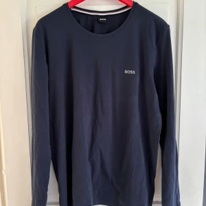 Mörkblå långärmad tröja från BOSS(äkta) - Snygg mörkblå långärmad tröja från BOSS i mjuk bomull. Vill bli av med dom finns en till vit kan göras en bundle. 