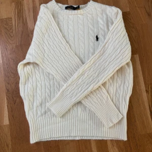 Ralphlauren Kabelstickad/Cabelknit vit M - Aldrig använd. Väldigt skön och mysig. Kommer med avklippt lapp då jag råkat klippa av den. Storlek M passar 170-180 bra
