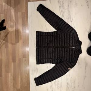 Colmar höstjacka - Stilren och lätt dunjacka från Colmar Originals, färg Nero Iron (svart). Klassisk modell utan huva med ståkrage och logga på ärmen. Två fickor med dragkedja. Mycket fint skick, inga fläckar eller skador. Nypris ca 4 000 kr. Passar perfekt för höst/vår – snygg både till vardags och på jobbet.