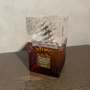 Lattafa Khamrah Dukhun parfym - Khamrah Dukhun från Lattafa är en elegant parfym med unik design. Flaskan har en lyxig känsla och passar perfekt för dig som vill sticka ut. Tillverkad i Förenade Arabemiraten. Perfekt för dig som gillar trendiga dofter och snygga flaskor.