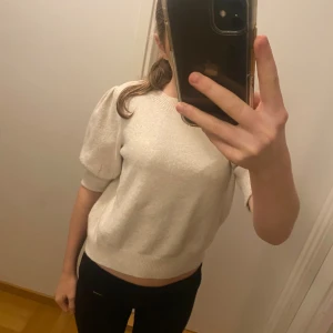 Beige stickad tröja med puffärm - Superfin beige stickad tröja med korta puffärmar och ribbade muddar. väldigt fin och skönt material. Används fåtal gånger💕