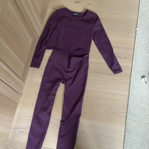 Lila leggings och tröja från Iconic, stl 146/152 - Säljer ett par lila leggings och tröja från Iconic i storlek 146/152. De är högmidjade och har en tight passform med stretchigt material, perfekta för träning eller chill. Färgen är djup lila och materialet känns mjukt och följsamt.