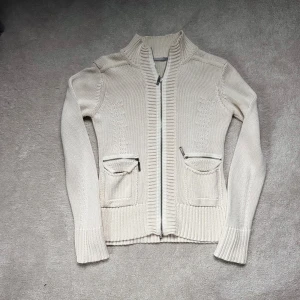 Vit stickad cardigan - Säljer en tvärfet vit cardigan i storlek M (sitter som s). Jättebra skick utan defekter och passar perfekt nu när de börjar bli lite kyligare ute!