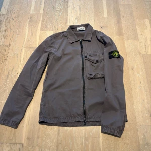 Brun/Grå overshirt från Stone Island - Säljer en brungrå overshirt från Stone Island. Jackan är minimalt använd och är i riktigt bra skick! 