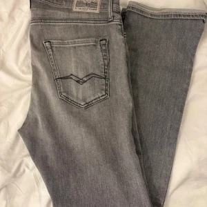 Grå jeansbyxor från Replay - Snygga grå jeansbyxor från replay med klassisk femficksdesign och coola detaljer på bakfickan. Jeansen har en rak passform och är tillverkade i slitstarkt denimmaterial.L32