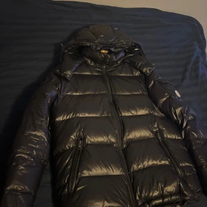 Svart Moncler maya  - Säljer min svarta Moncler maya jacka då jag vill ha en ny i annan färg! Den är i super bra skick! använd fåtal gånger men knappt något som syns. Vid frågor är det bara att skriva så svarar jag!   