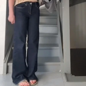 Mörkblå bootcut jeans - Snygga mörkblå jeans med bootcut passform och klassiska fickor. Jeansen har en normal midja och är tillverkade i ett robust denimtyg. Perfekta för dig som gillar en tidlös och clean look.