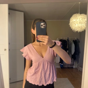 Ljusrosa blus/topp med volangärm och knyt i ryggen🩷 - Supersöt ljusrosa blus med v-ringning och volangärmar, har en öppen rygg med knytband