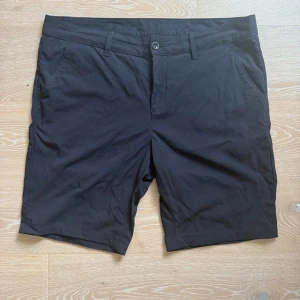 Svarta shorts från Peak Performance - Snygga svarta shorts från Peak Performance med klassisk passform. De har två sidofickor, två bakfickor och bälteshällor. Perfekta för sommardagar och har en stilren look som funkar till det mesta. Materialet känns lätt och bekvämt.