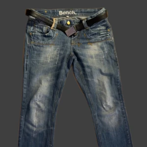 Blå Bench jeans  - Snygga blå jeans från Bench med slitna detaljer och cool tvätt. Klassisk femficksmodell, raka ben och gult kontrastsömmar.Perfekta för dig som gillar en avslappnad streetstil.