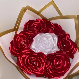 Eternal Roses / Evighets Rosor - Unik bukett med satinrosor i röd och vit, dekorerade med små pärlor i mitten. Rosorna är handgjorda och har en lyxig känsla tack vare det glansiga materialet och den eleganta rosetten längst ner på buketten.