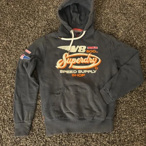 Superdry hoodie (sällsynt) - Säljer nu denna eftertraktade hoodie ifrån Superdry. Skick 8/10. Rikigt snygg och passar perfekt nu till hösten! Obs kan gå ner i pris vid snabb och smiddig affär!