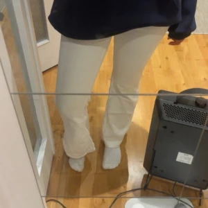 Vita bootcut byxor  - Snygga vita bootcut byxor med skön passform. Byxorna har en klassisk siluett med utsvängda ben. Perfekta för dig som vill ha en stilren och trendig look.