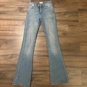 Bootcut jeans i ljusblå denim från ONLY - Bootcut jeans från ONLY i ljusblå denim. Jeansen har medel hög midja och utsvängda ben för en trendig siluett. Hör av dig vid frågor❣️