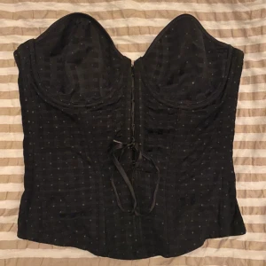 Corset - Snygg corset som är svart med diskreta rutor skulle säga att kuporna är B