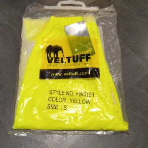 Veltuff gula regnbyxor med reflex - Gula regnbyxor från Veltuff i PU-material med hög synlighet och reflexband runt benen. Perfekta för att synas i mörker eller dåligt väder. Elastisk midja för skön passform och vattentätt material som håller dig torr. Aldrig använda. Fortfarande i original förpackning 