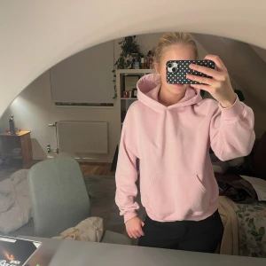 Ljusrosa hoodie från Gina Tricot - Mysig ljusrosa hoodie från Gina Tricot, basically basics-kollektionen. Klassisk modell med huva, magficka och ribbade muddar. Perfekt oversized fit för chill dagar. Tillverkad i mjuk bomullsblandning som känns skön mot huden.