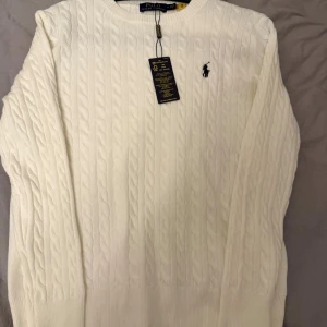 Polo Ralph Lauren Sweater Vit - En Polo sweater i färgen vit. Helt sprillans ny då den satt lite för tajt för mig. Riktig snygg och perfekt material för att hålla värmen nu i vintern. Vid funderingar är de bara att skriva 👍. Pris går alltid att diskutera!