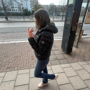 Colmar jacka - Svart pufferjacka från Colmar med huva och dragkedja framtill. Jackan har quiltad design och två sidofickor med dragkedja. Perfekt för kyliga dagar och har en snygg, sportig look som funkar till jeans och sneakers. Finns två små hål på ärmen men inget som syns o tänks på när man har på sig den. Säljer då jag har en annan vinterjacka. Pris kan såklart diskuteras