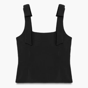 Svart linnetopp med breda axelband - Snygg svart linnetopp med breda axelband och stilrena detaljer. Toppen har en rak och tight passform med fyrkantig halsringning. Perfekt att matcha med jeans eller kjol för en cool och enkel look.