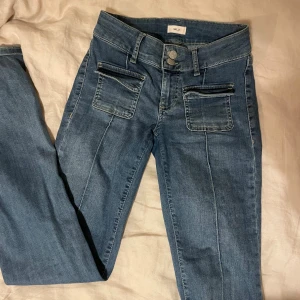 Blå jeans med fickor från Nelly - Super snygga jeans, lite skavda nere vid fötterna! 