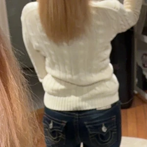 Vit tröja Ralph Lauren - Säljer en vit kabelstickad tröja från Ralph Lauren med v-ringad hals och långärmad passform. Tröjan har ett litet broderat logomärke på bröstet. Äkta köptes för 2500kr 