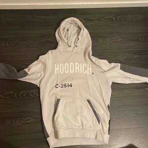 Grå hoodie och byxa från Hoodrich med tryck - 👕 Grå Hoodrich tracksuit – hoodie + byxa! Snygg ljusgrå Hoodrich hoodie och matchande byxa med vit logga framtill och världskarta tryckt på ryggen 🌍 Huvan har snörning, känguruficka och mörkgrå detaljer på ärmar och sidor. Perfekt set för dig som gillar streetwear och vill ha en clean, fräsch fit 👟  💰 800 kr – snabb affär 