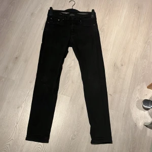 Svarta jeans från Jack & Jones - Svarta jeans från Jack & Jones, modell Comfort Fit Mike. Klassisk femficksdesign med raka ben och normal passform. Jeansen är tillverkade i ett mjukt och slitstarkt bomullsmaterial med en snygg svart ton som passar till allt.