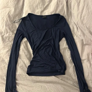 Marinblå långärmad topp Gina Tricot - Säljer en enkel och stilren marinblå långärmad topp från Gina Tricot i storlek S. Toppen har rundad halsringning och är gjord i mjuk bomull som känns skön mot huden. Perfekt att matcha med jeans eller kjol för en clean look.