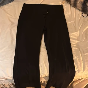 Svarta kostymbyxor från Gina Tricot - Snygga svarta kostymbyxor från Gina Tricot i storlek S. Byxorna har en klassisk rak passform och är tillverkade i ett mjukt och följsamt material som ger en clean look. Perfekta för dig som gillar stilrena och enkla plagg.