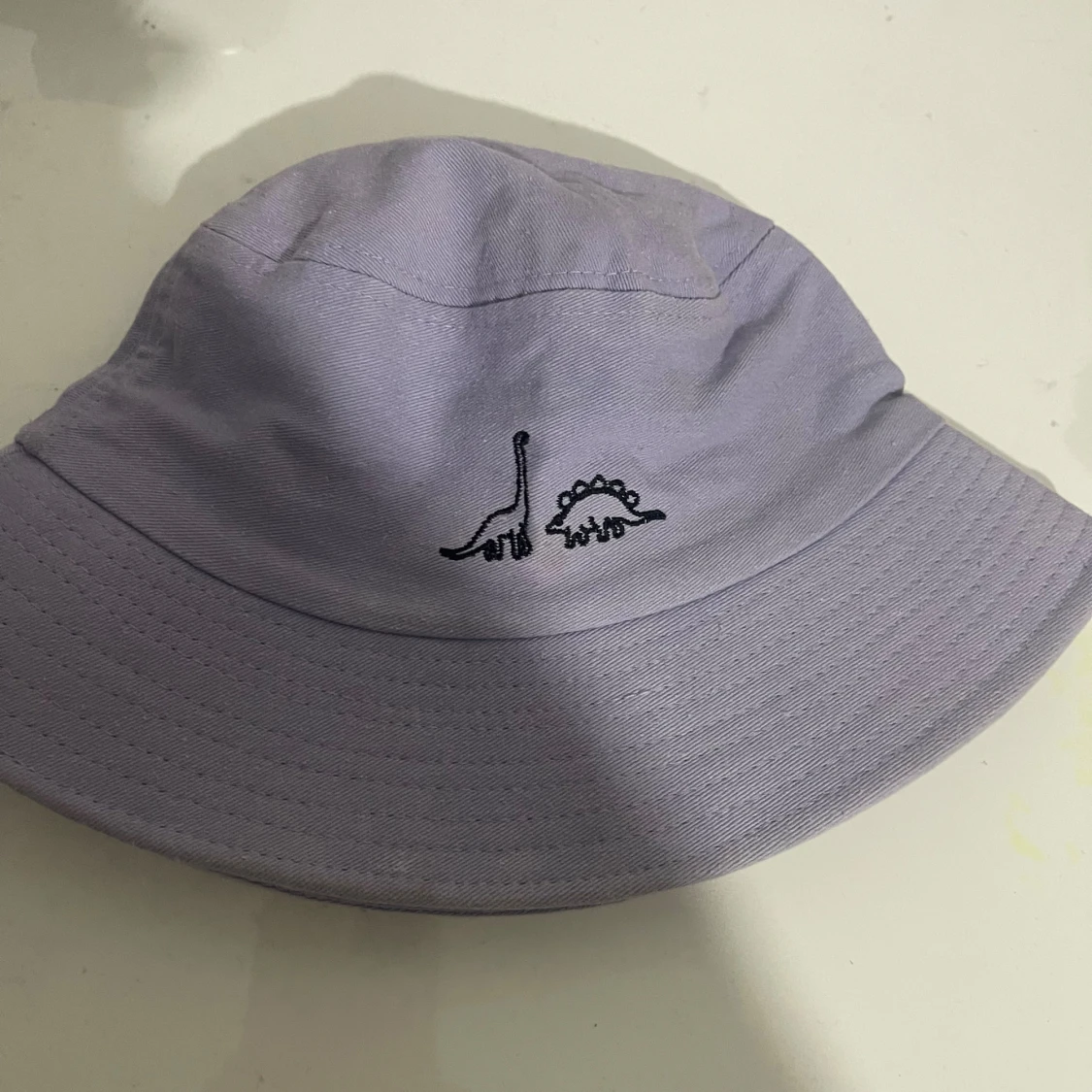 Ljuslila bucket hat med dinosaurier